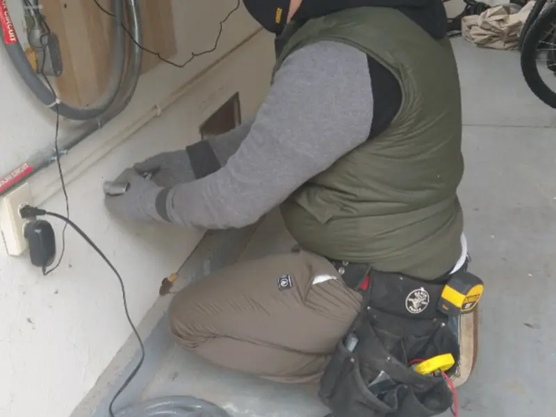 Electrician performing outlet wiring in a Enon garage